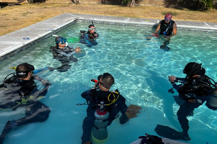 Group of divers practicing scuba skills in a pool.