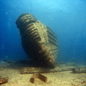 Underwater view of a sunken shipwreck resting on the ocean floor.